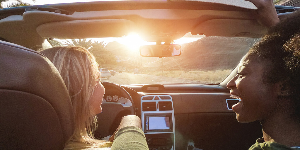 Two Female Passengers in a Convertible at Sunset